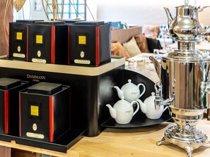 A display of Dammann Frères tea boxes and teapots on a wooden table. - greet hotel Marseille Parc Chanot Vélodrome by Accor (Marseille)