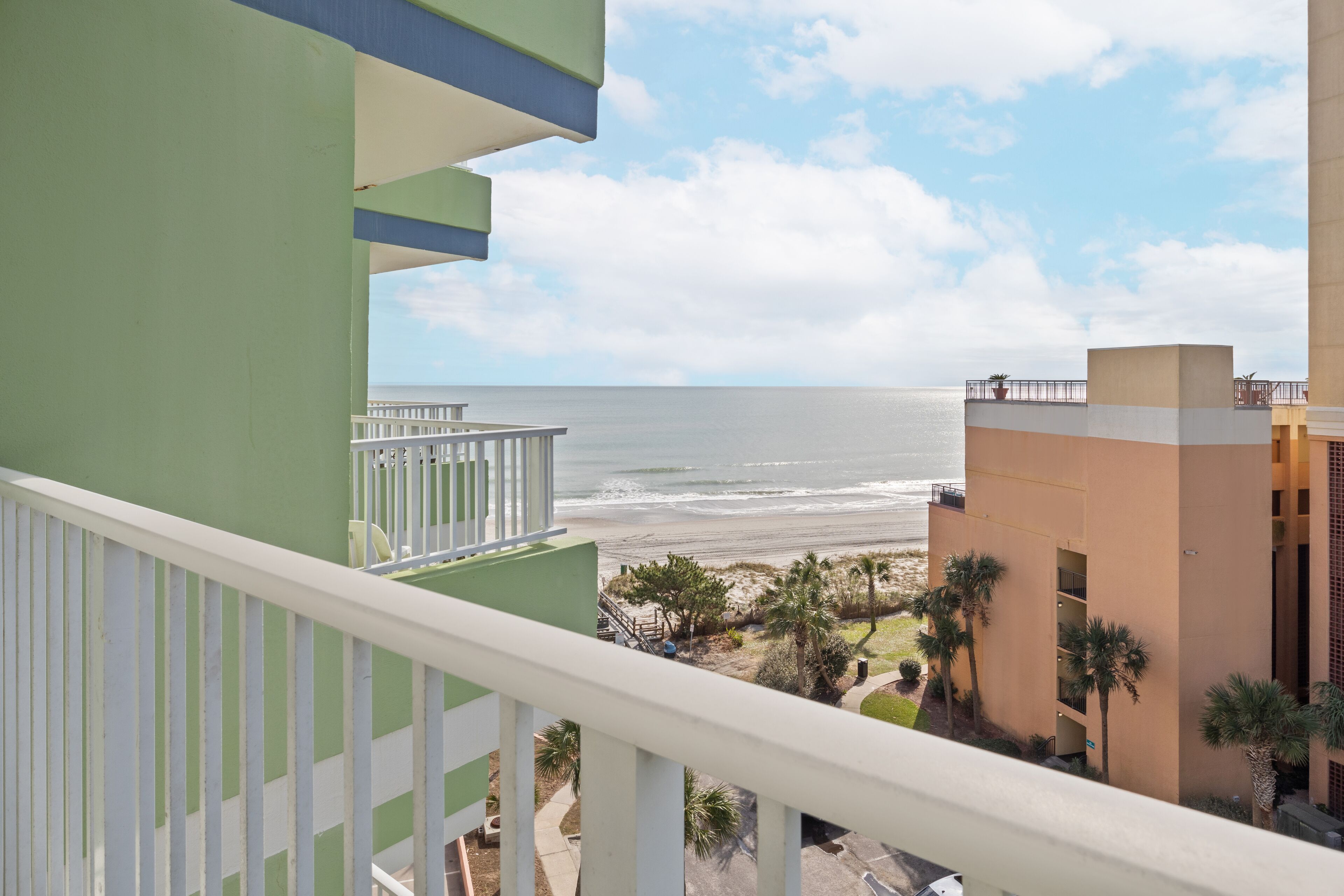 Ein Balkon mit Blick auf Strand und Meer.