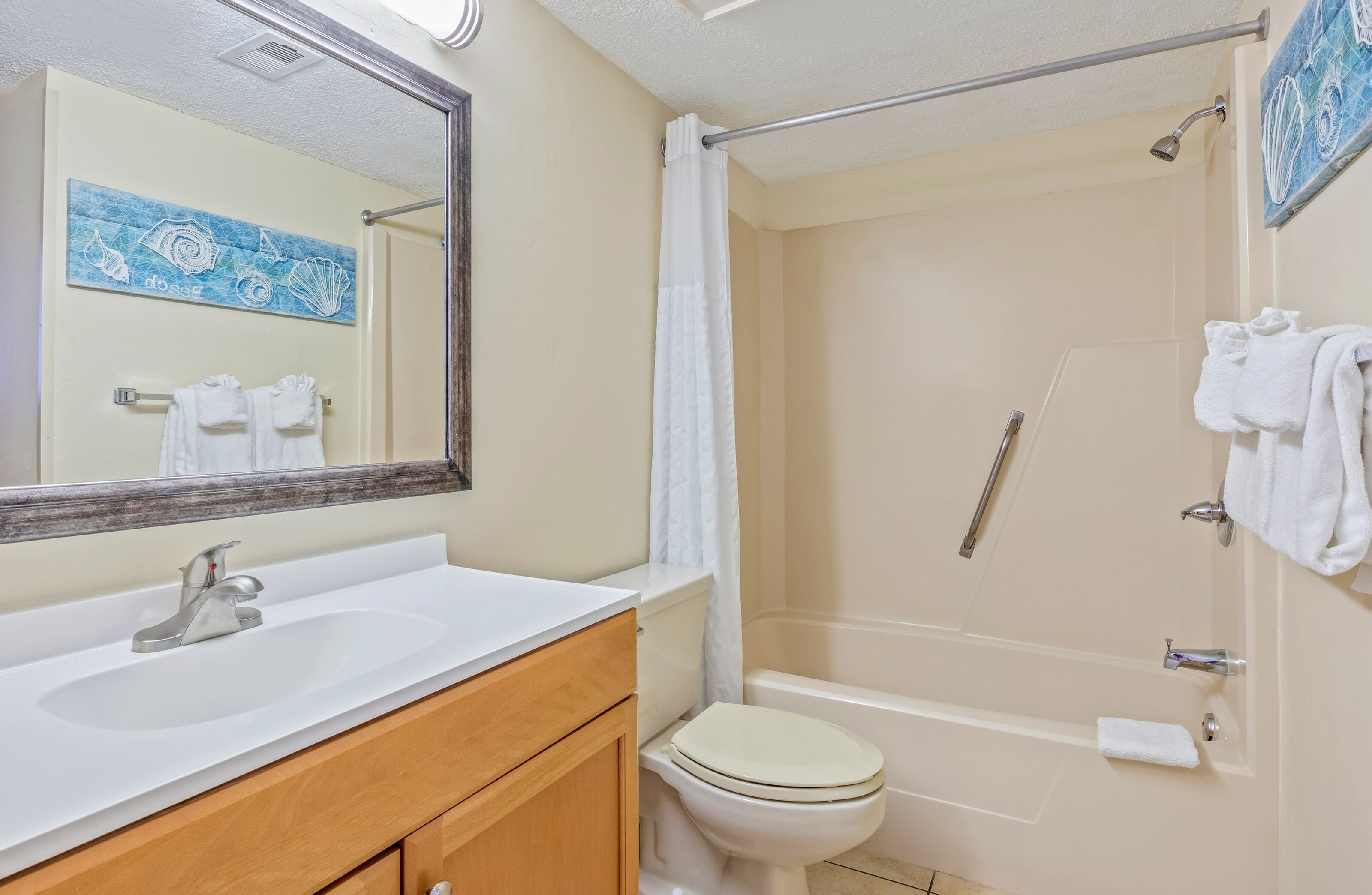 A bathroom with a sink, toilet, and shower.