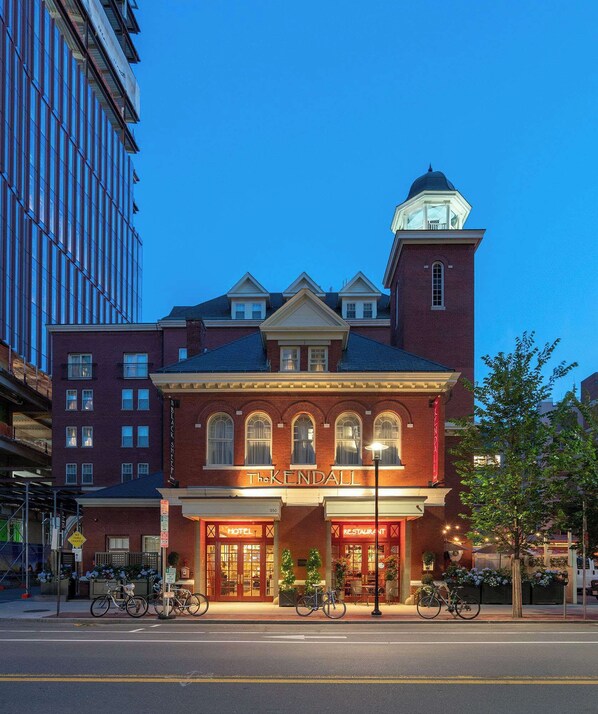 Un hotel histórico con una imponente torre de reloj, una fachada clásica y una entrada bien iluminada.