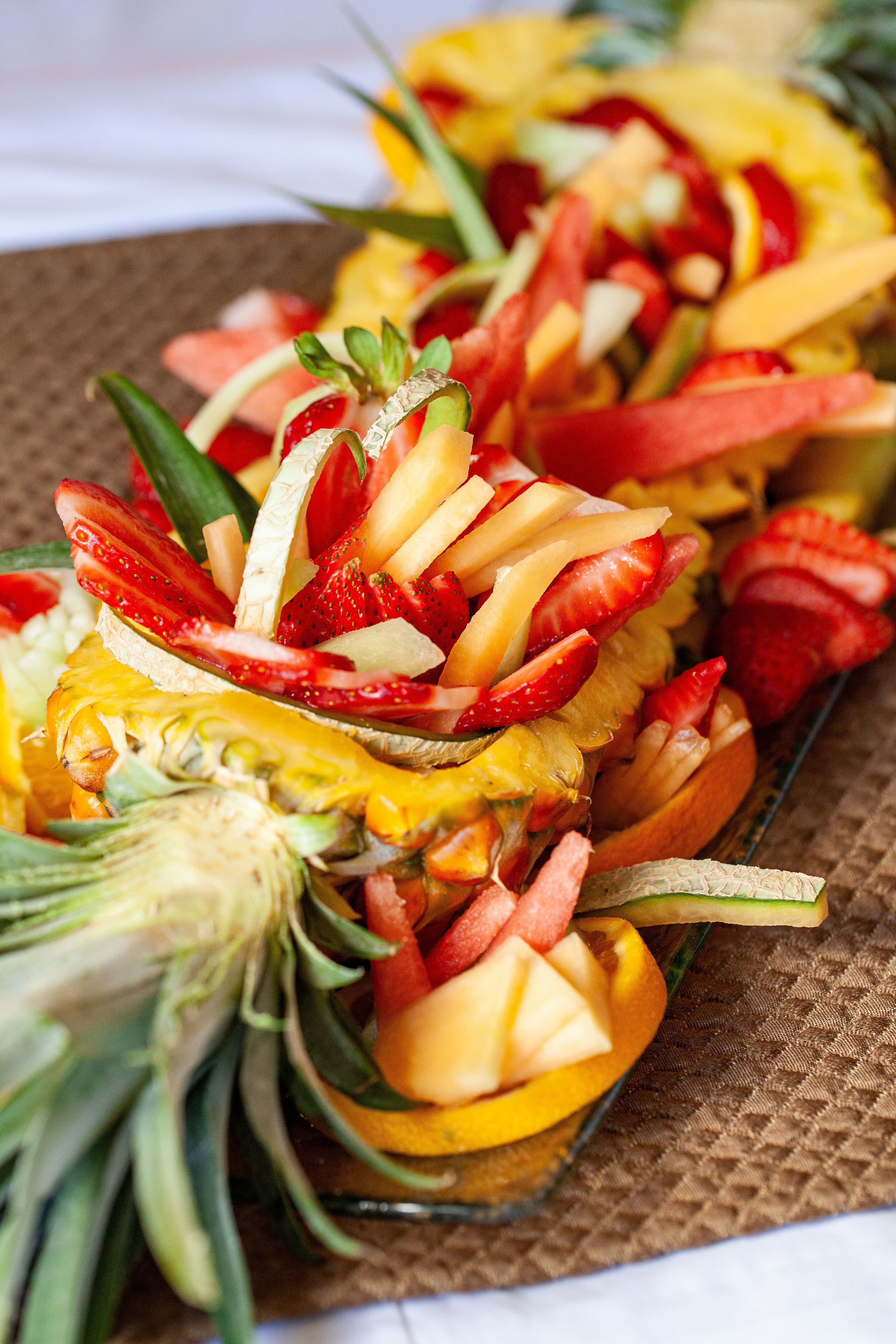 A fruit platter with sliced strawberries, pineapple, and melon.