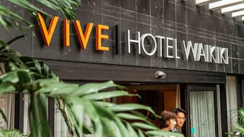 Segnaletica di un hotel con la scritta 'VIVE HOTEL WAIKI' e un ingresso visibile con porta in vetro.
