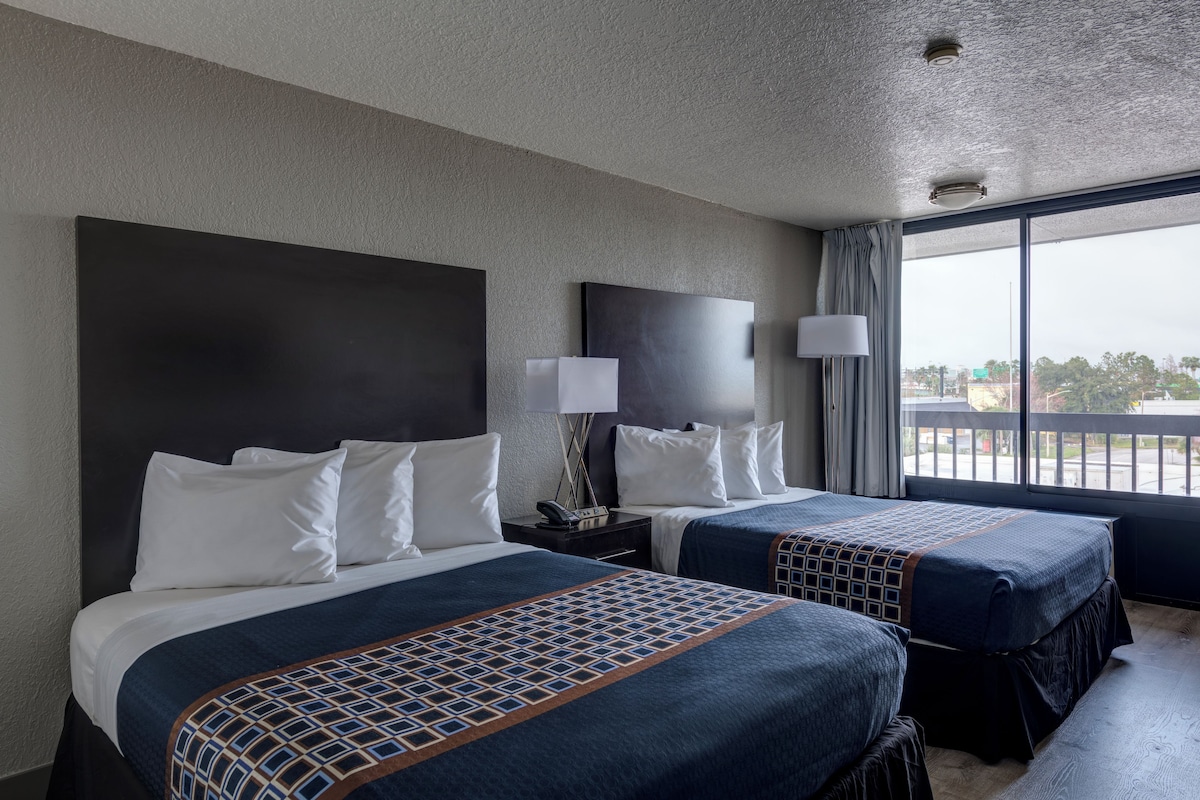 Ein Hotelzimmer mit zwei Betten, einem großen Fenster mit Blick und einem modernen Design.