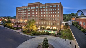 A large hotel with multiple floors, a courtyard with a swimming pool, and a landscaped garden area. - Carnegie Hotel & Spa (Johnson City)