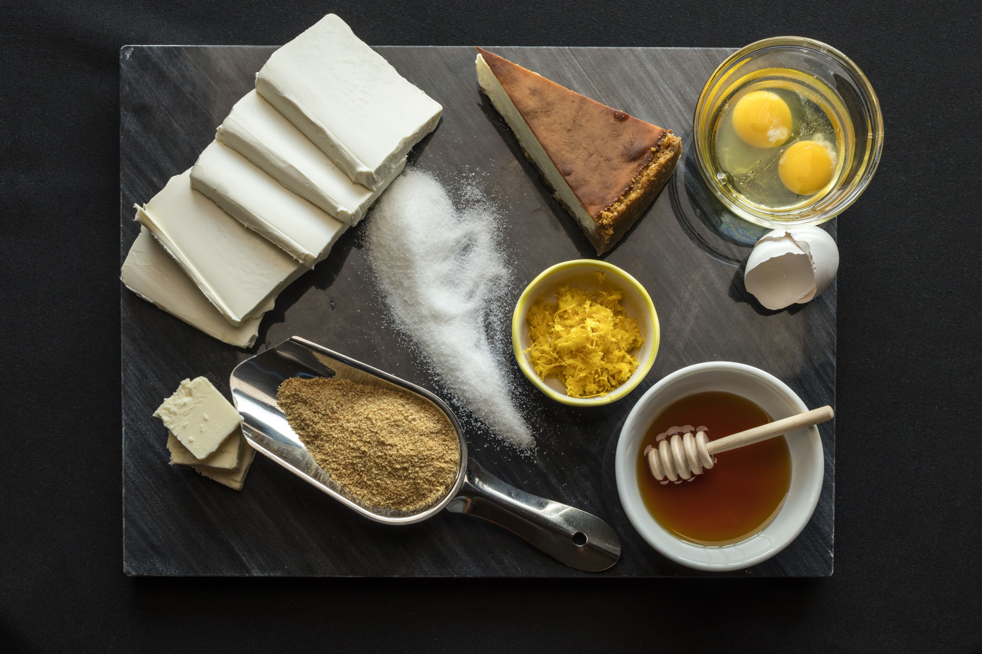 A tray with various food items including cheese, a pie, eggs, and honey.