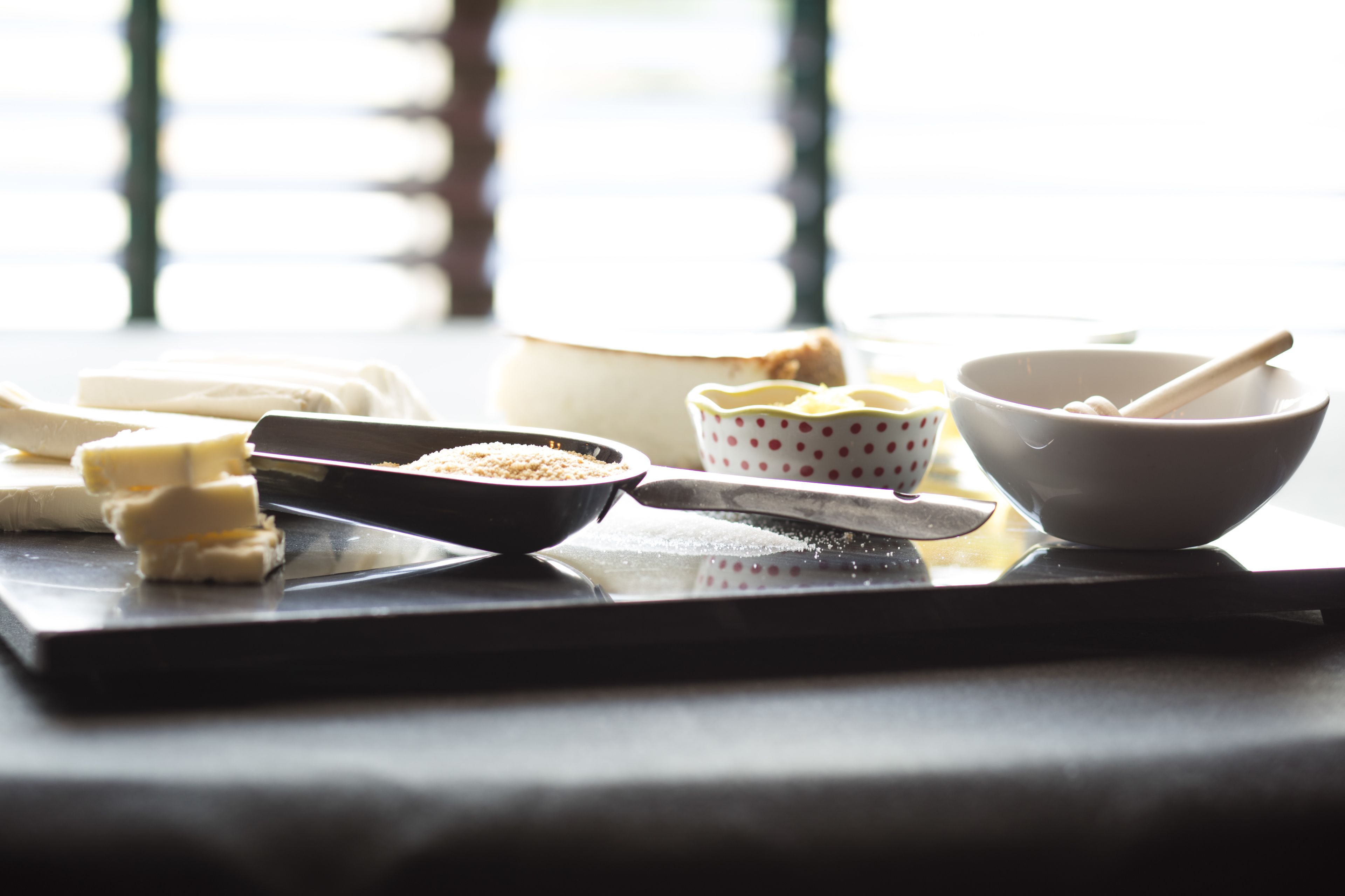 Una encimera de cocina con diversos ingredientes para hornear y utensilios.