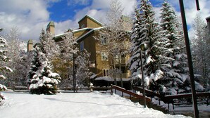 A snow-covered landscape with a wooden building, snow-laden trees, and a clear sky. - Westwind at Vail (Vail)
