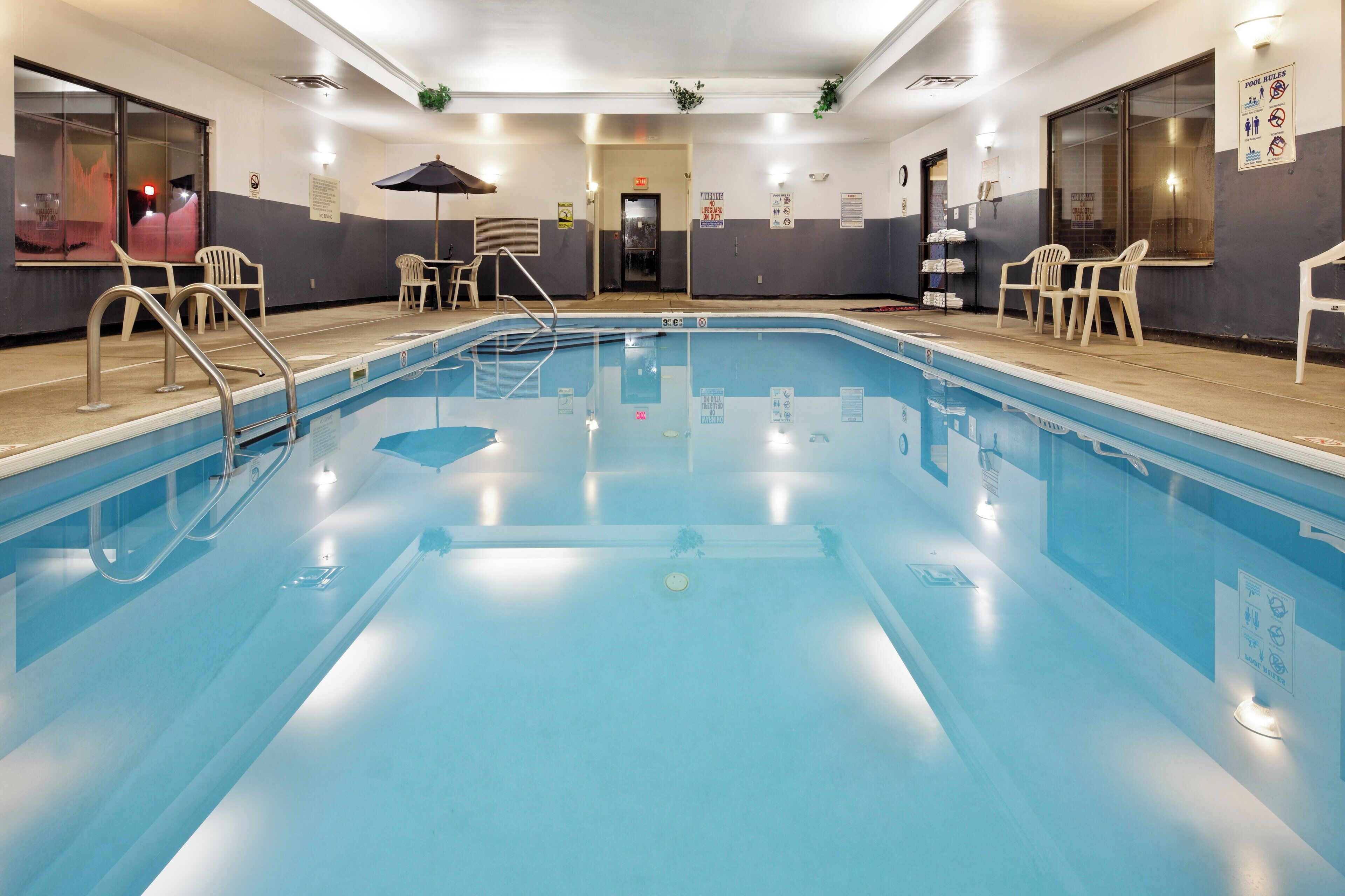 Una piscina al aire libre de temporada, sombrillas