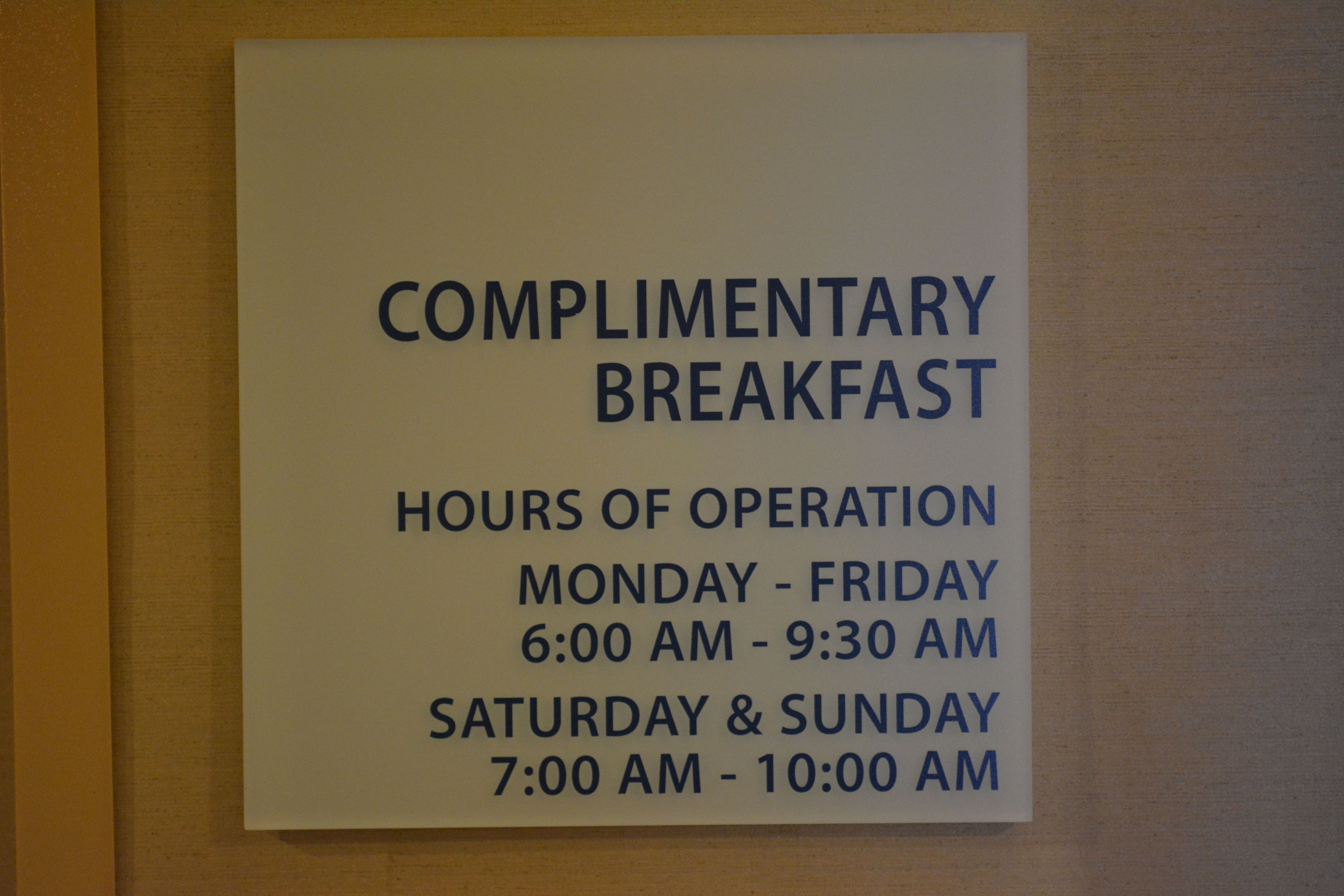 Un panneau indiquant les heures de service du petit-déjeuner gratuit : du lundi au vendredi, de 6 h 00 à 9 h 30, et le samedi et le dimanche, de 7 h 00 à 10 h 00.