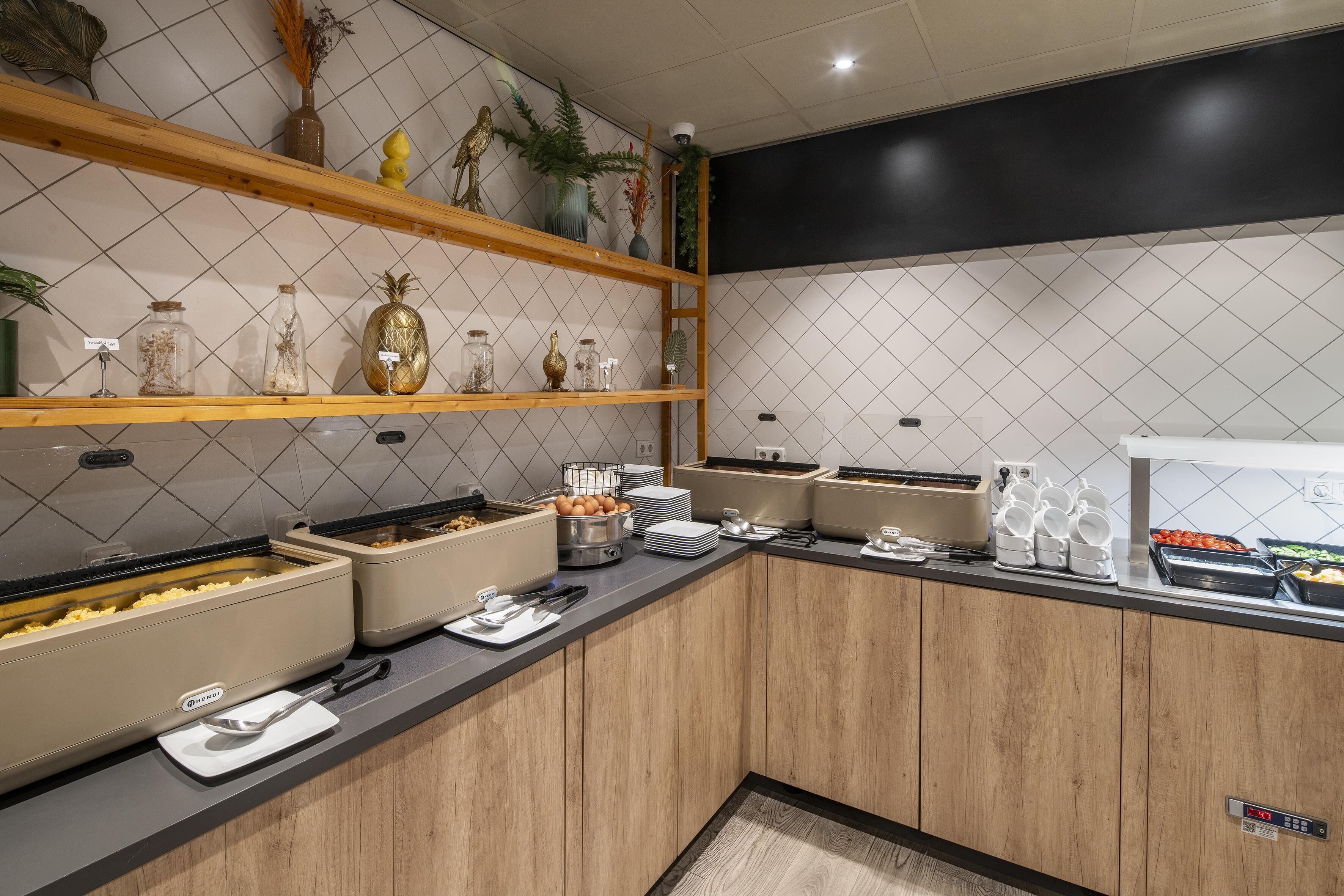Una cucina moderna con mobili in legno, un piano di lavoro nero e diversi alimenti e utensili.