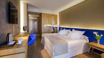Una habitación de hotel con cama, escritorio, silla y un adorno de pared.
