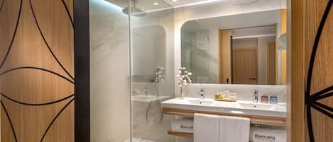 A modern bathroom with a glass shower enclosure, a double sink vanity, and a large mirror.