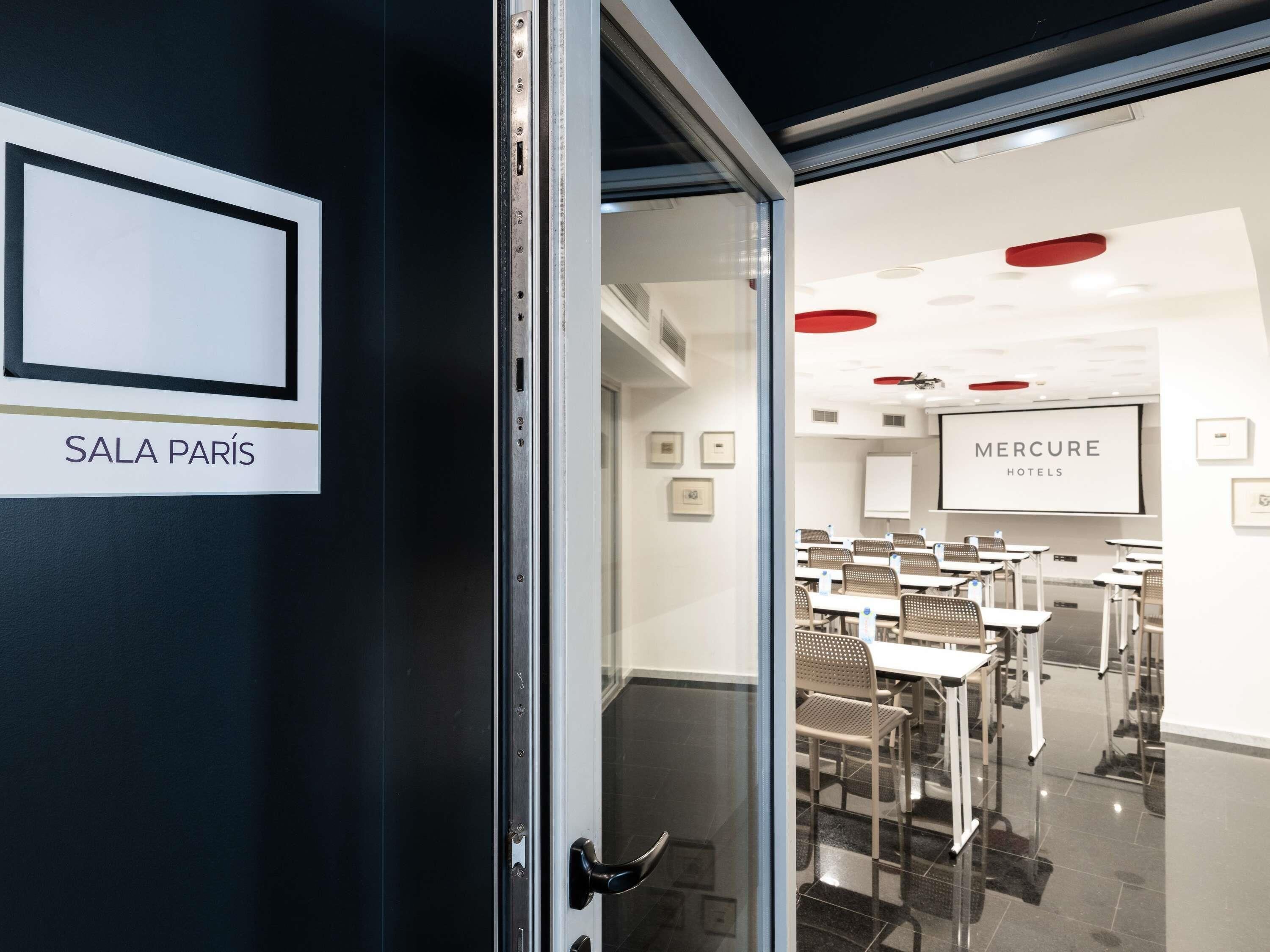 Un vestíbulo de hotel con un cartel que dice 'SALA PARIS' y 'MERCURE HOTELS'.