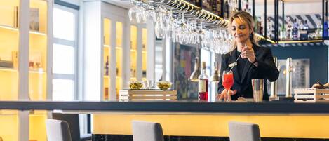 A bar area with a bartender, bar counter, and seating.