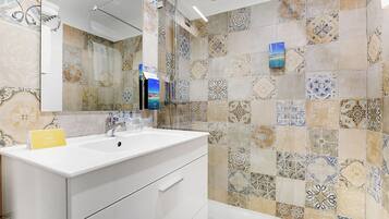 Suite, 2 habitaciones, vistas al mar | Baño | Artículos de higiene personal de diseño, secador de pelo y toallas