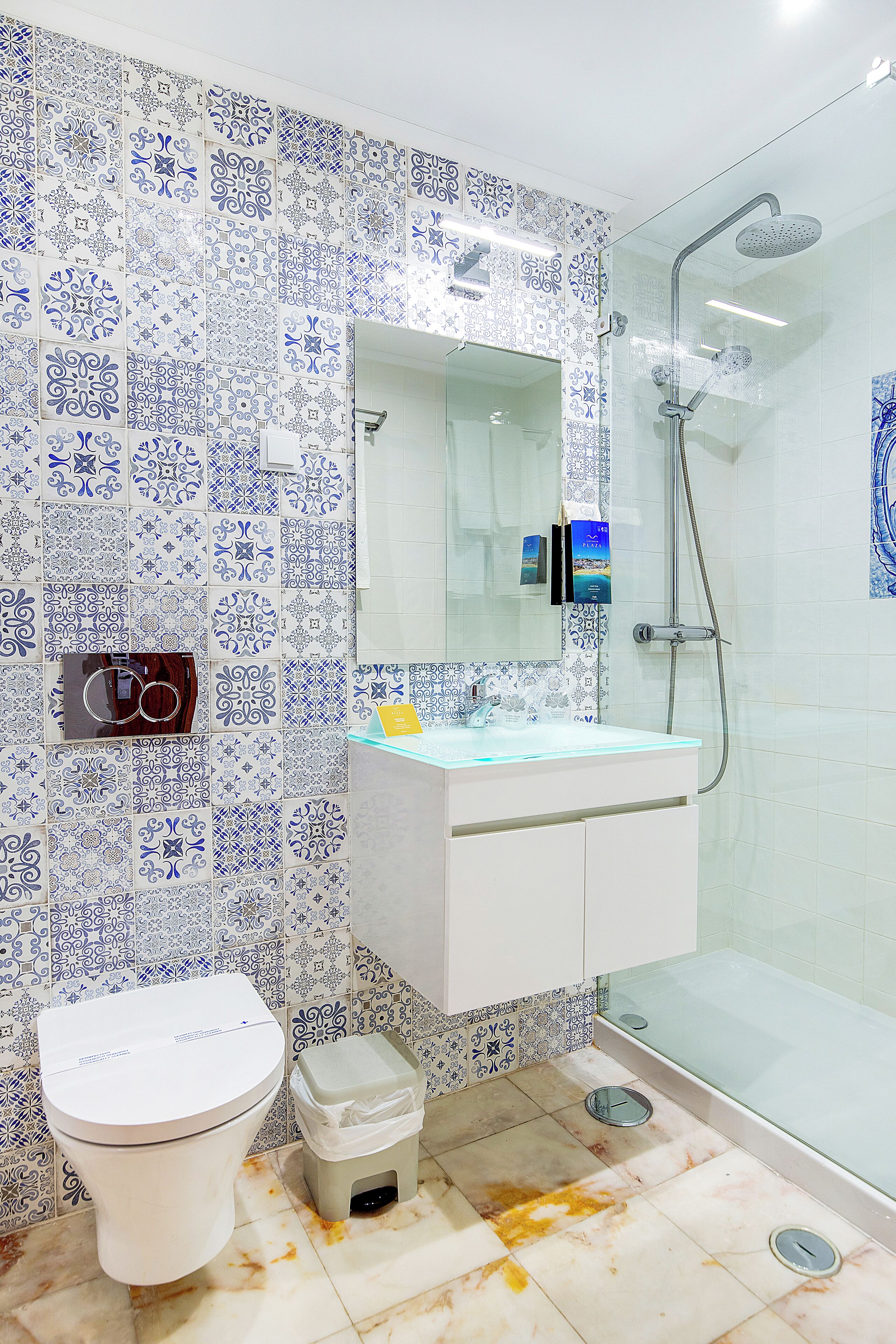A bathroom with a white toilet, a sink with a mirror, and a shower area.