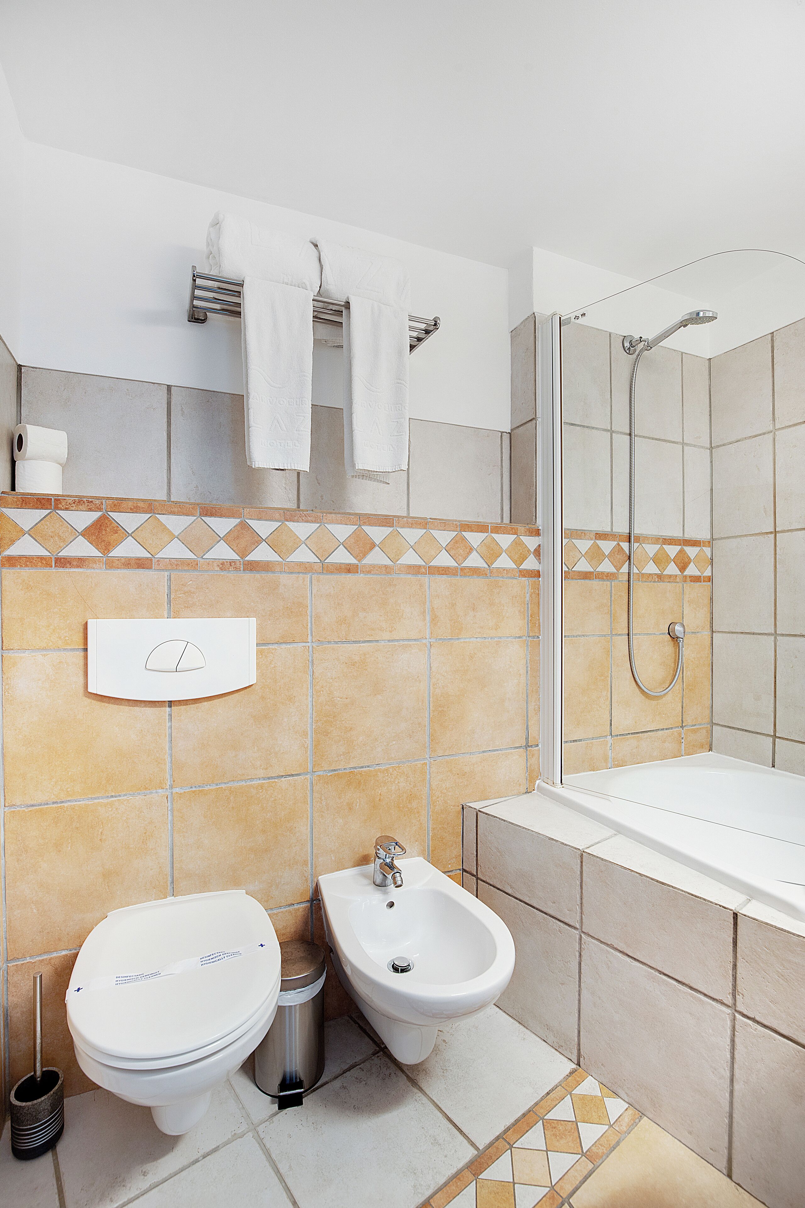 A modern bathroom with a shower, toilet, bidet, and sink.