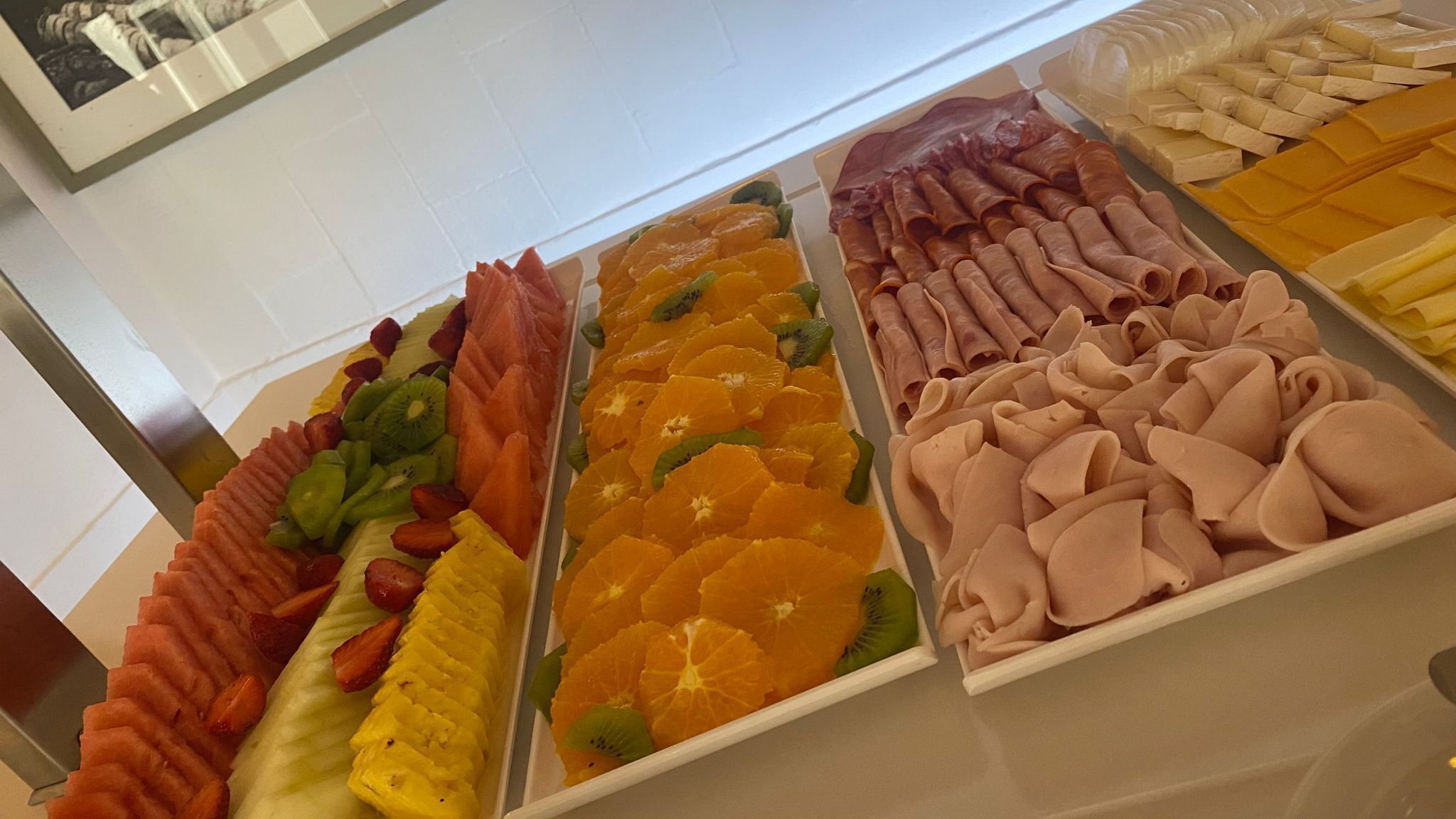 Un buffet proposant une variété de plats, notamment des fruits, des viandes et des fromages.