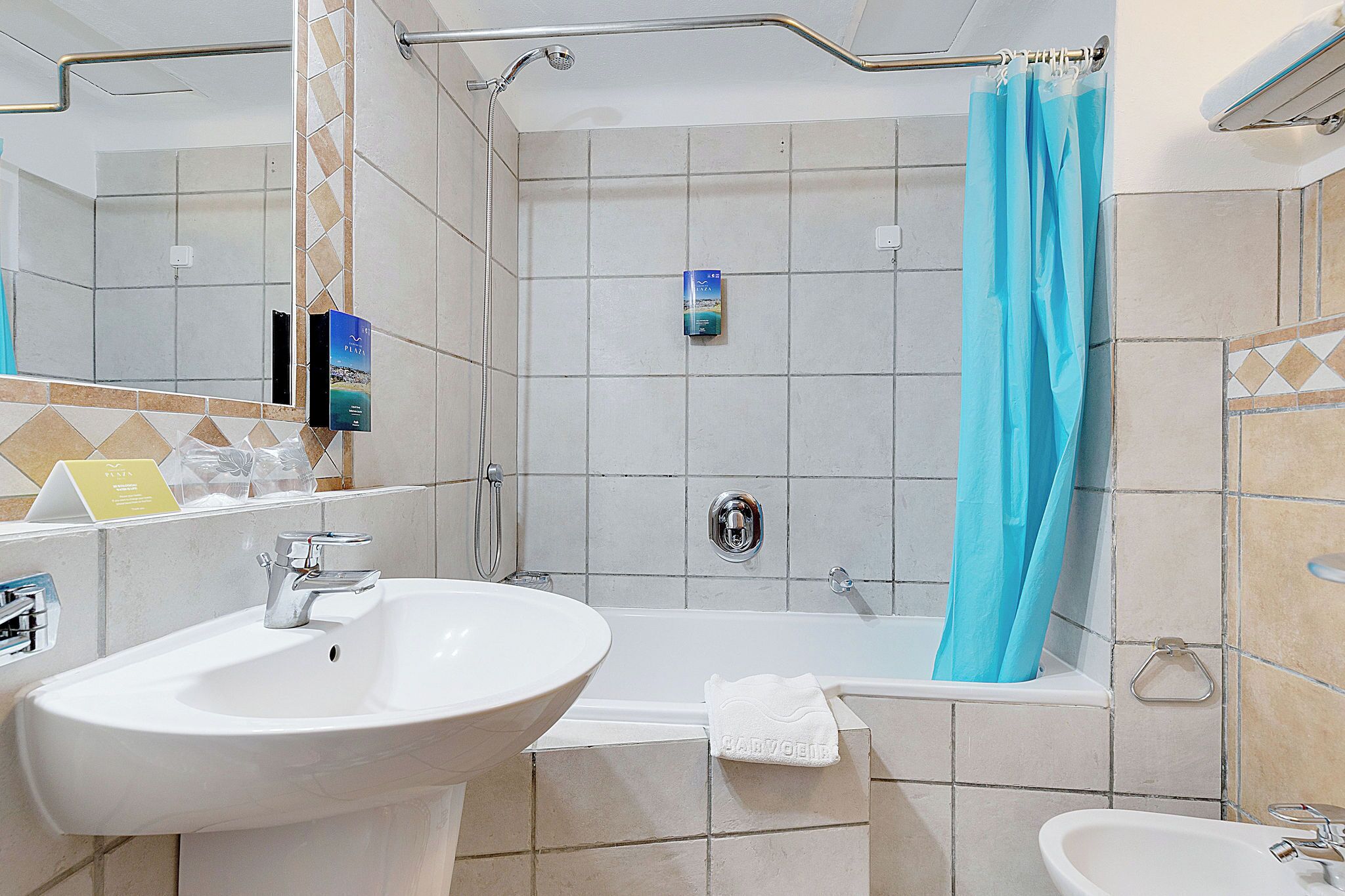 Een badkamer met een badkuip, een douche en twee wastafels.