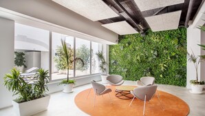 A modern interior with a green wall, large windows, and a circular seating area. - Planet Hotels One Adults Only +16 (Palma de Mallorca)