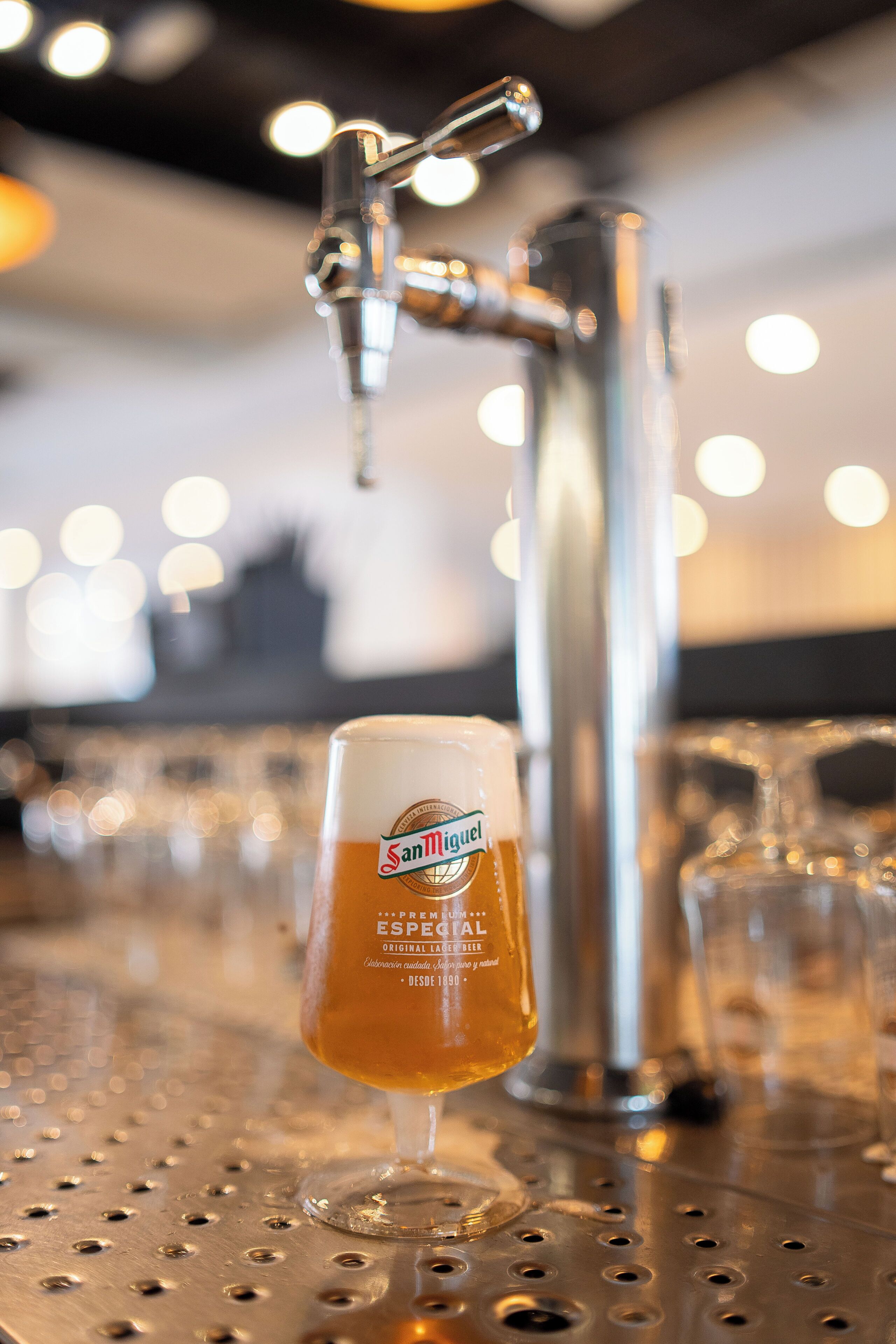 Ein Wasserhahn mit einem Bierglas davor.