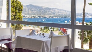 A table set for dining with a view of the sea and mountains. - Globales Honolulu (Calvia)