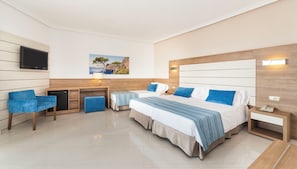 A hotel room with a large bed, two bedside tables, a desk, a chair, a TV, and a painting on the wall. - Globales America (Manacor)