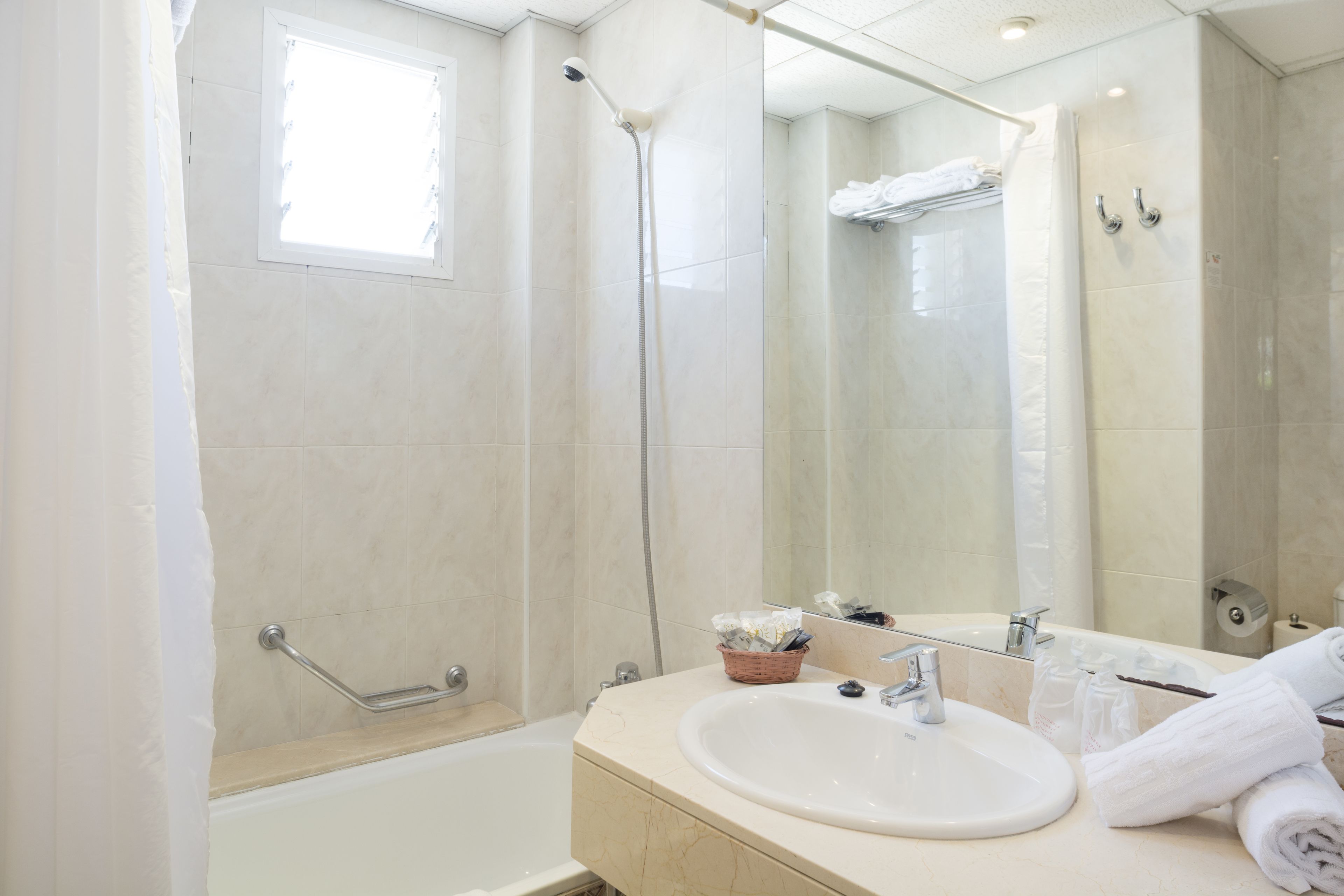 A modern bathroom with a bathtub, a shower, and a sink.