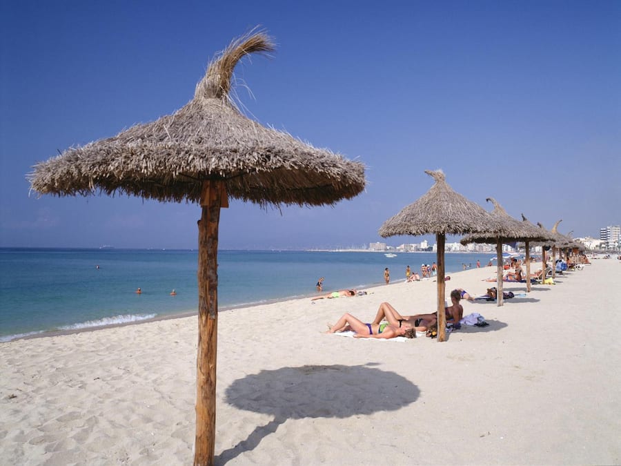 Una playa cerca, arena blanca, sillas reclinables de playa, sombrillas