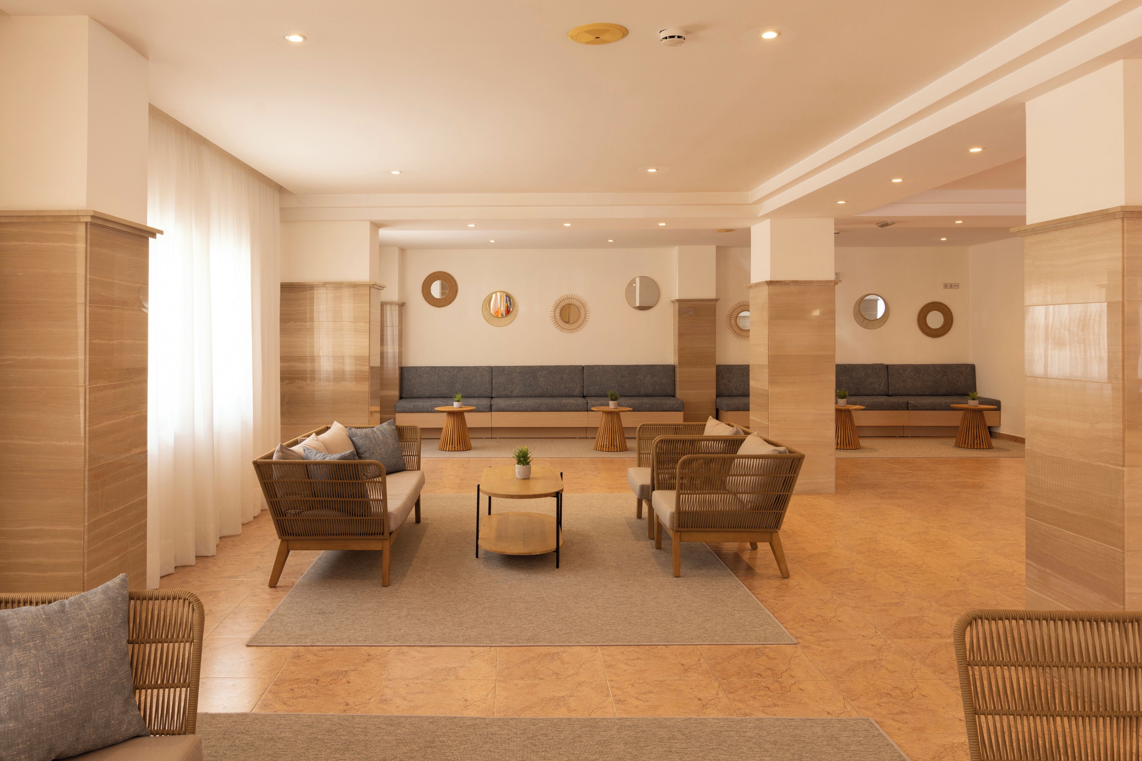 Um hall amplo com área de estar, sofás e uma mesa de centro.