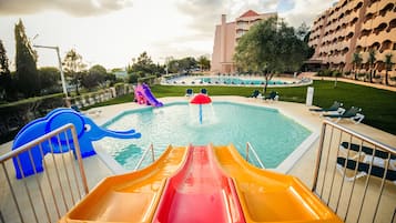 A pool area with slides and a building in the background.