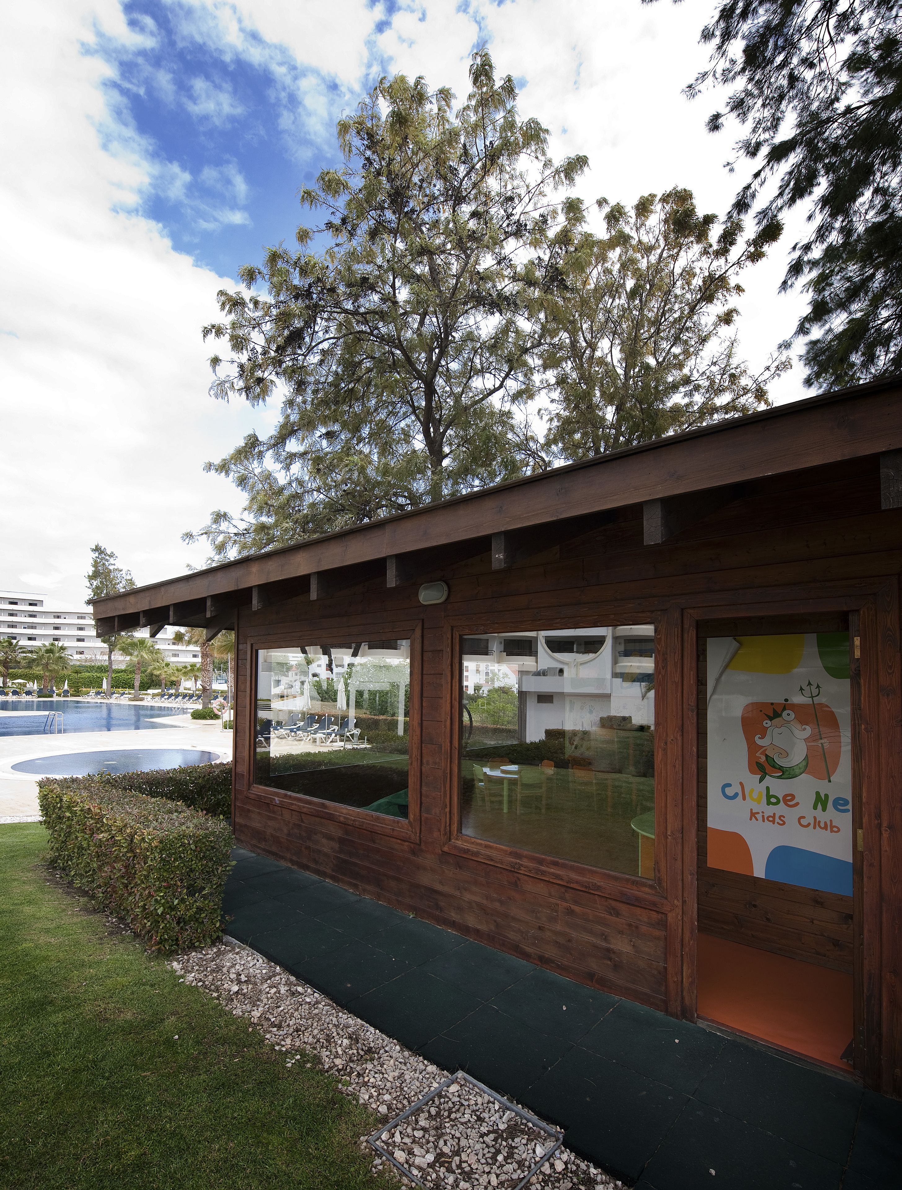 A children's club building with large windows and a wooden facade.