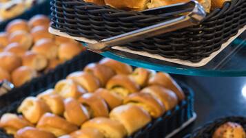 Un buffet proposant une variété de produits de boulangerie présentés dans des paniers.