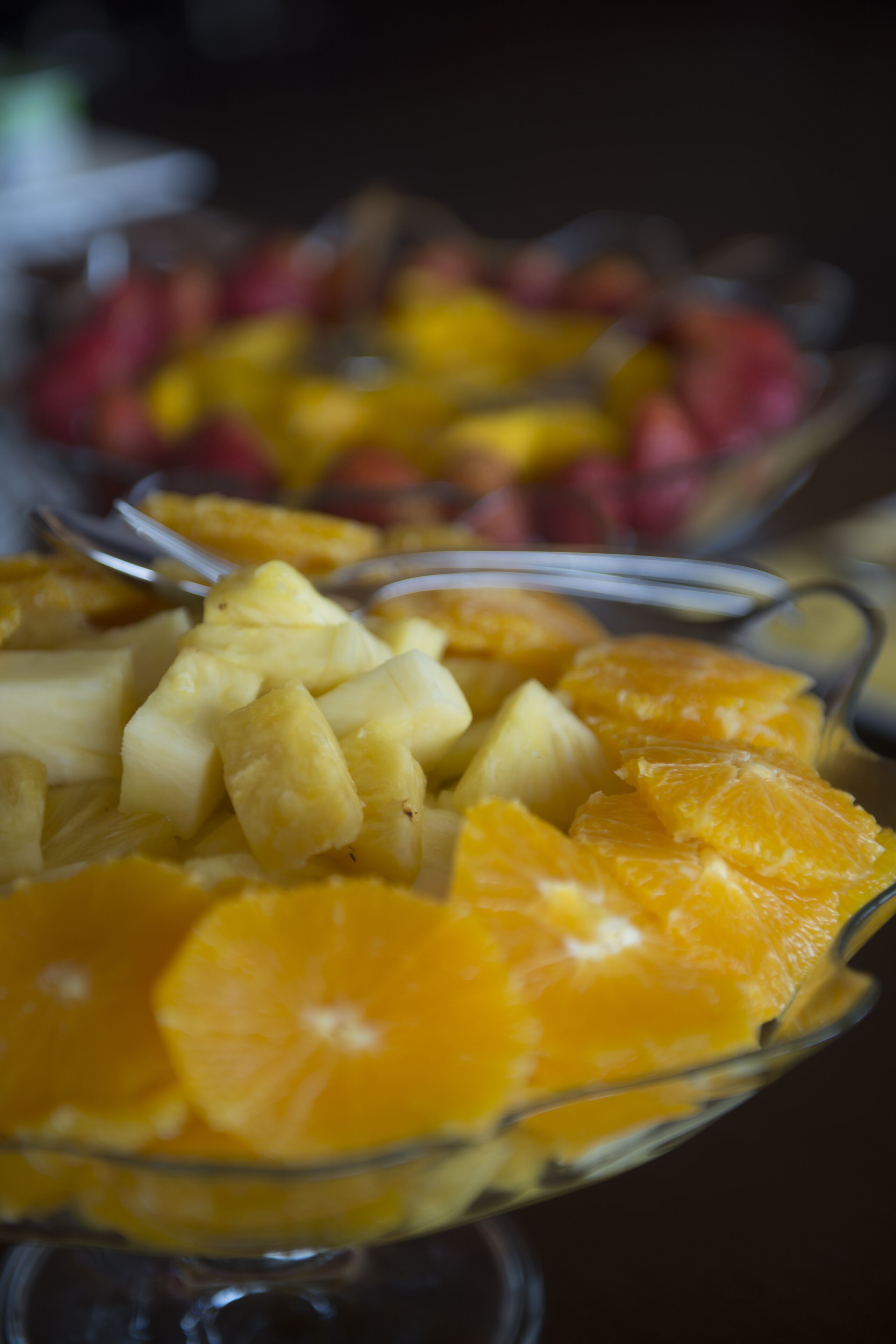 Un tazón de frutas con trozos de piña y gajos de naranja.