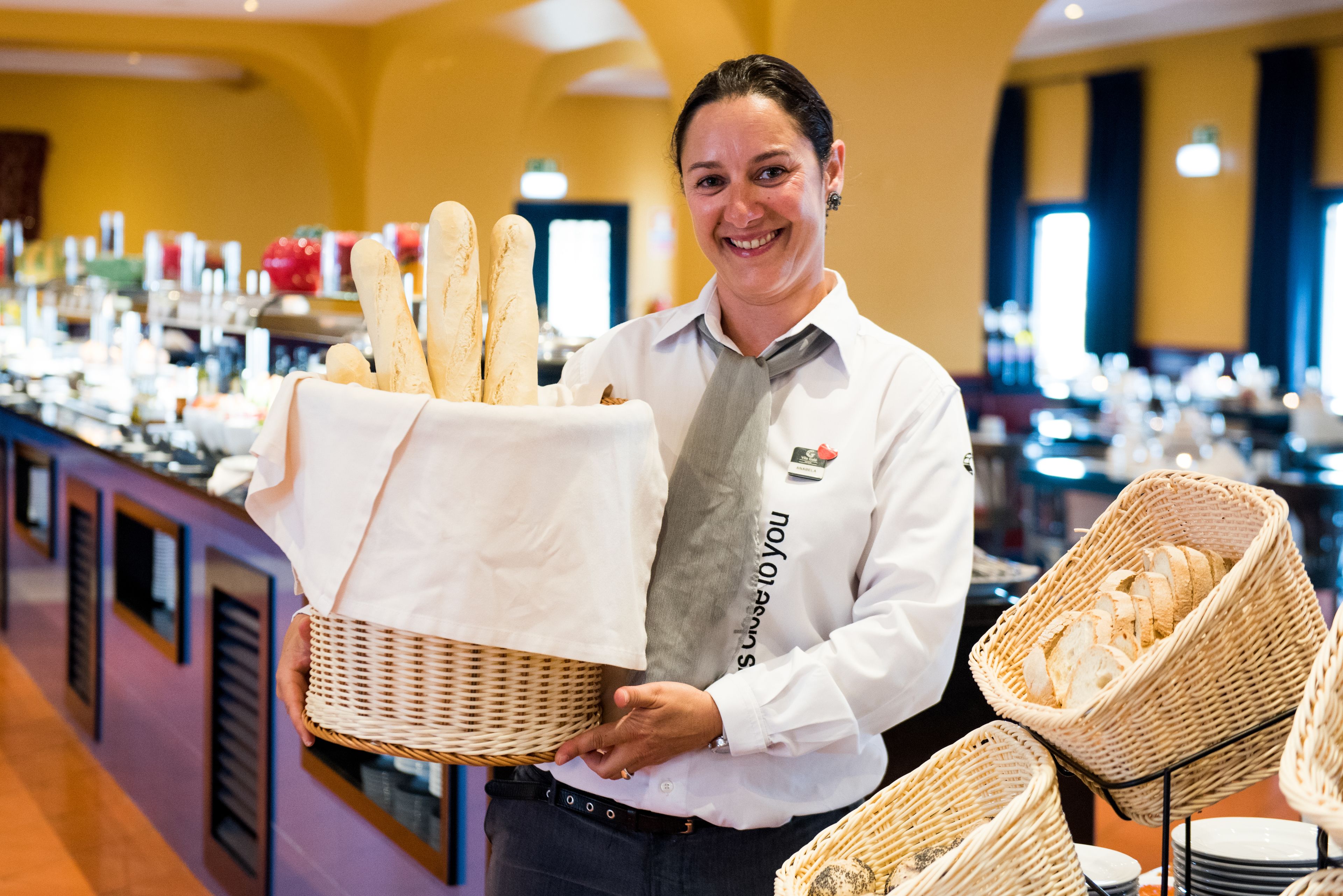 A buffet setup with baskets of bread and a variety of food items.