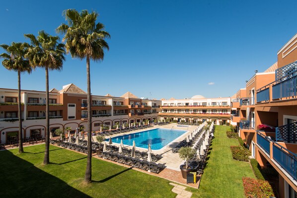 Una piscina cubierta, una piscina al aire libre, sombrillas, tumbonas