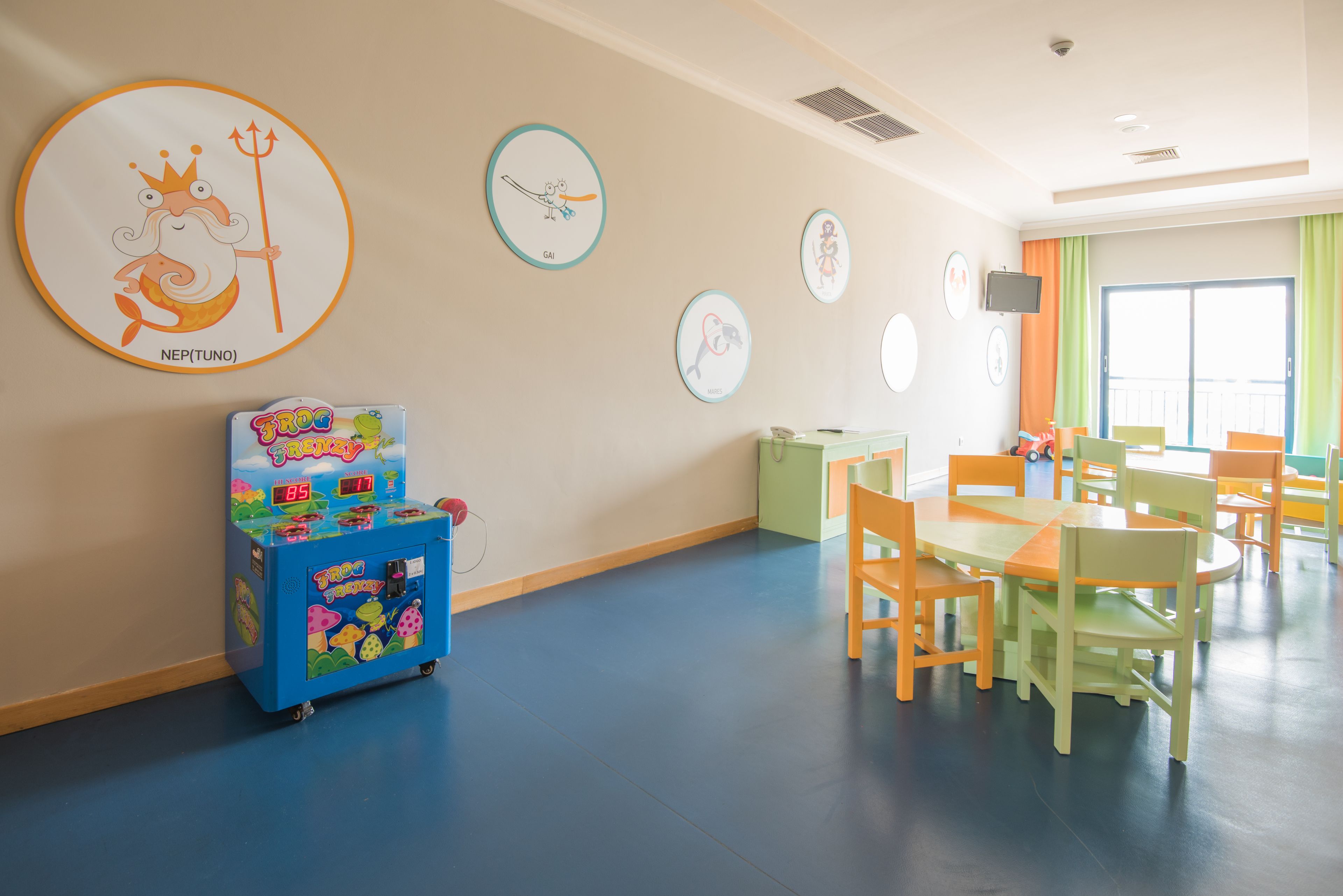 A children's play area with colorful furniture and educational wall decorations.