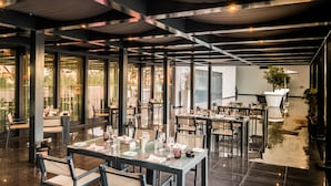 A modern restaurant with tables set for dining, large windows, and a ceiling with exposed beams. - Vila Gale Opera Hotel (Lisbon)