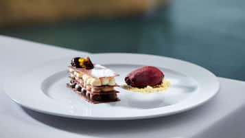 Un postre sobre un plato blanco, con una piscina al fondo.