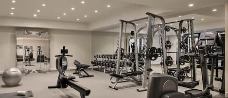 A modern gym with various exercise equipment, including treadmills, weight machines, and free weights.