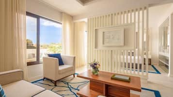 Una habitación de hotel moderna con un sofá, una mesa de centro y vistas al exterior.