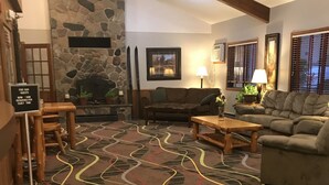 A cozy lobby with a stone fireplace, wooden furniture, and a patterned carpet. - Walker Hotel (Walker)