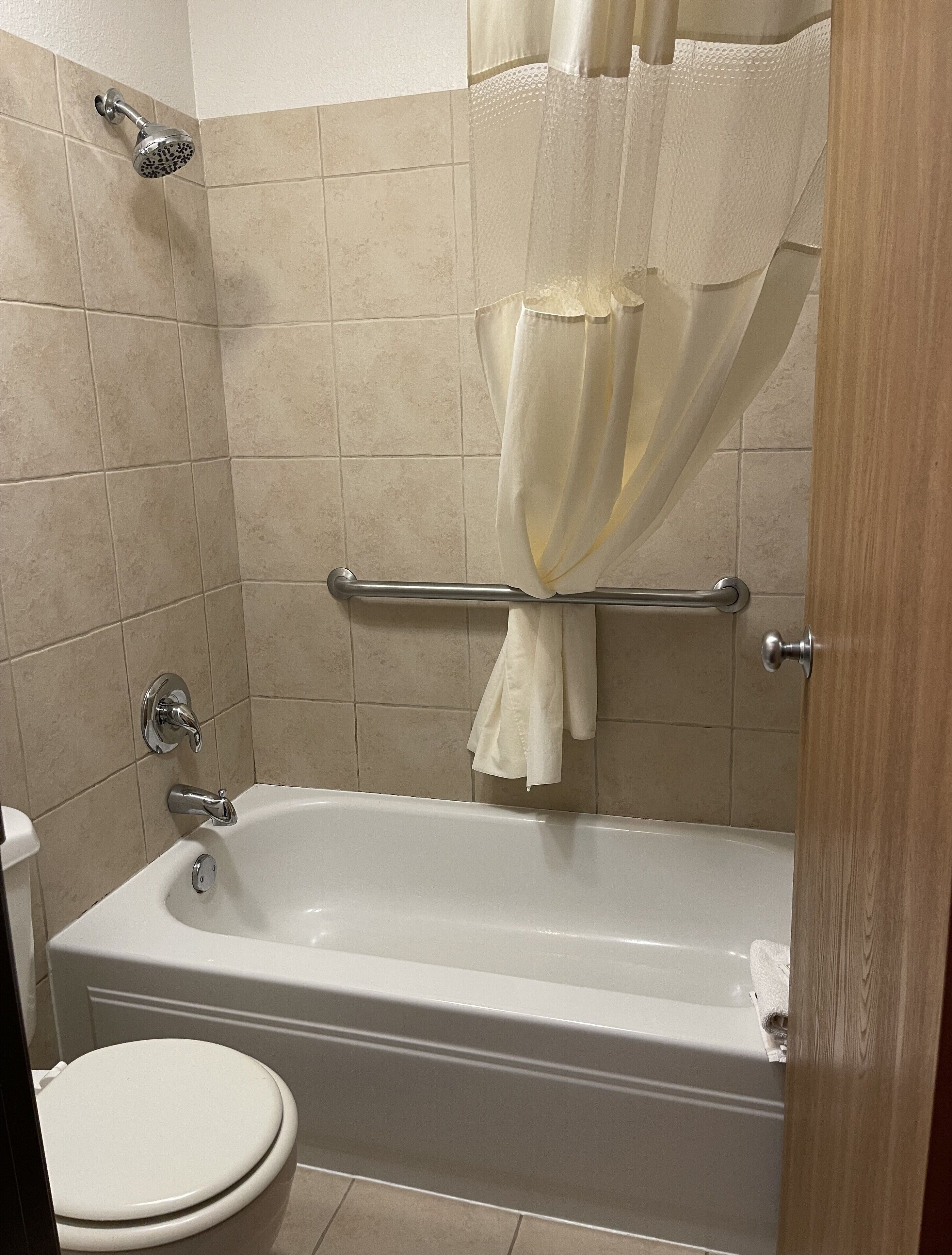 A bathroom with a bathtub, toilet, and shower.