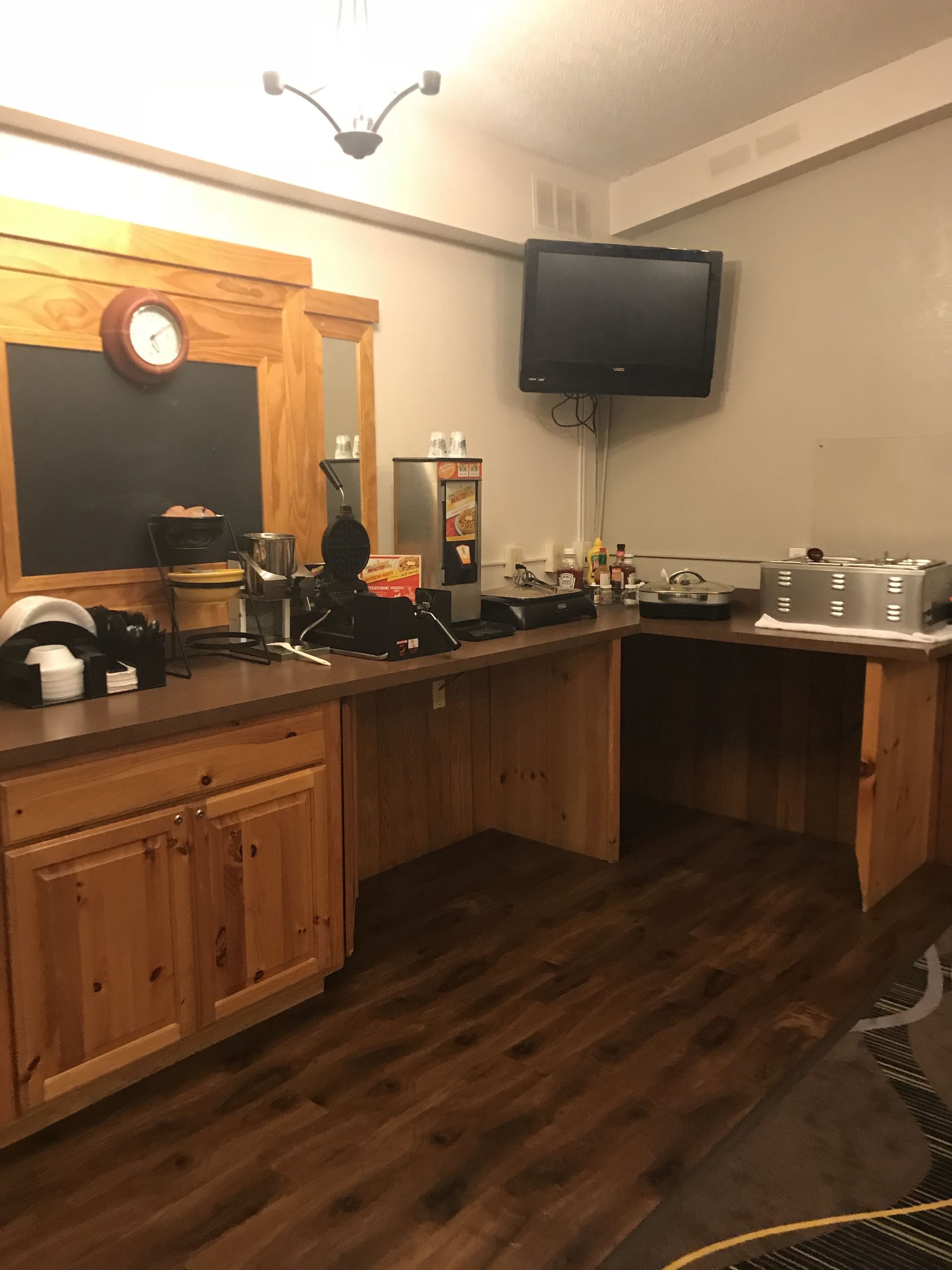 Una cucina con mobili in legno, un forno a microonde, un tostapane e una macchina per il caffè.