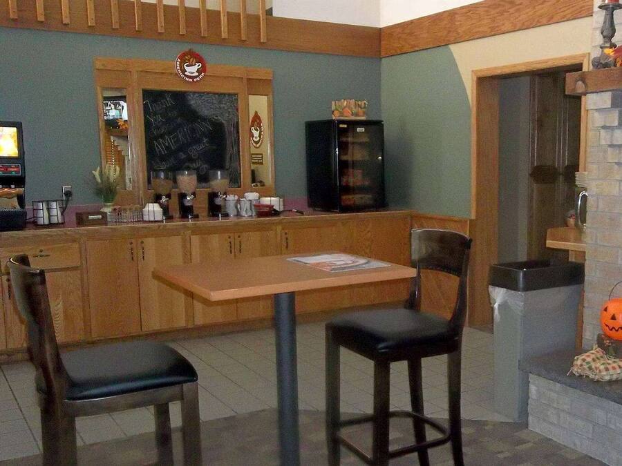 Un restaurante pequeño y acogedor con muebles de madera, una máquina de café y un menú en una pizarra.