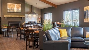 Una sala de estar moderna con chimenea, comedor y cocina.