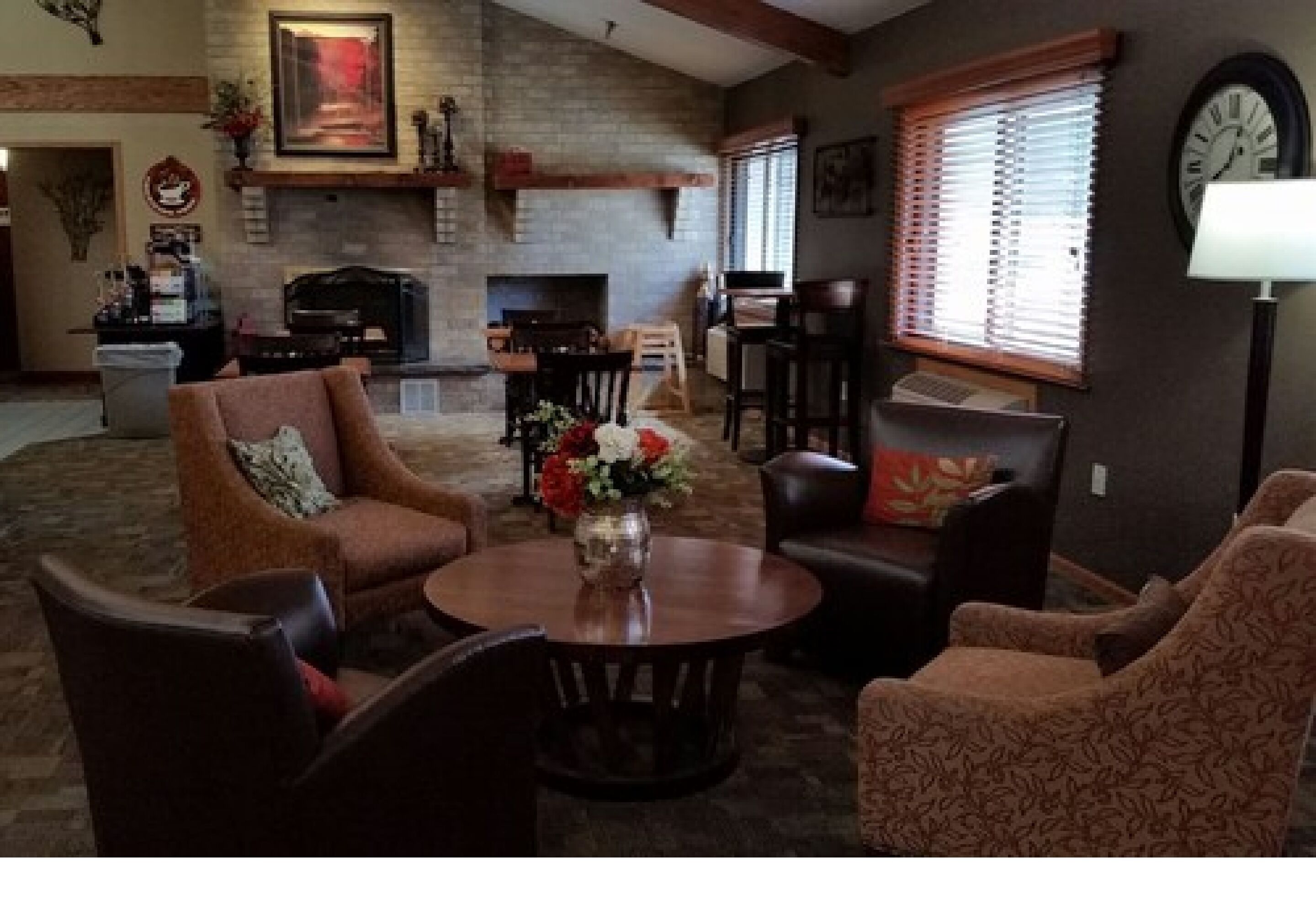 Un salon doté d’une cheminée, d’une table basse ronde et de fauteuils à motifs.