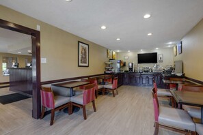 Enjoy dining and entertainment in this restaurant with booths, tables, and a central counter featuring a flat-screen TV.