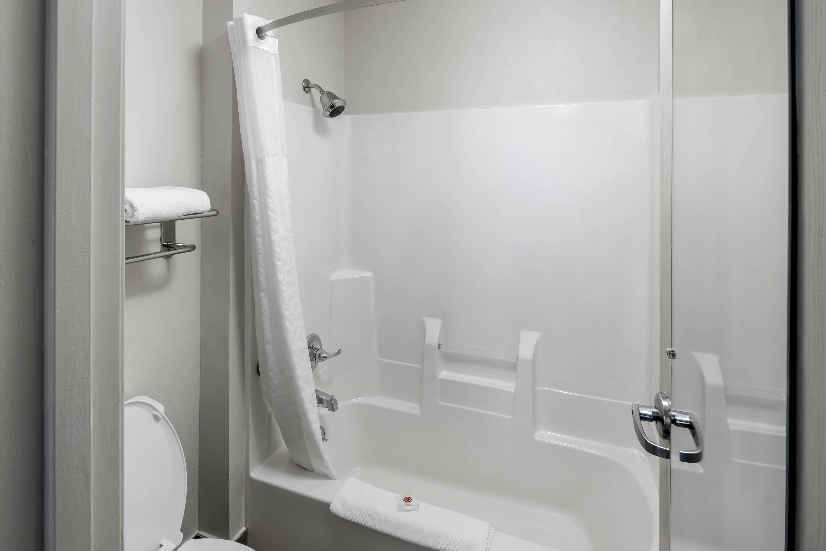 Un baño moderno con cabina de ducha de vidrio, inodoro y perchero para toallas.