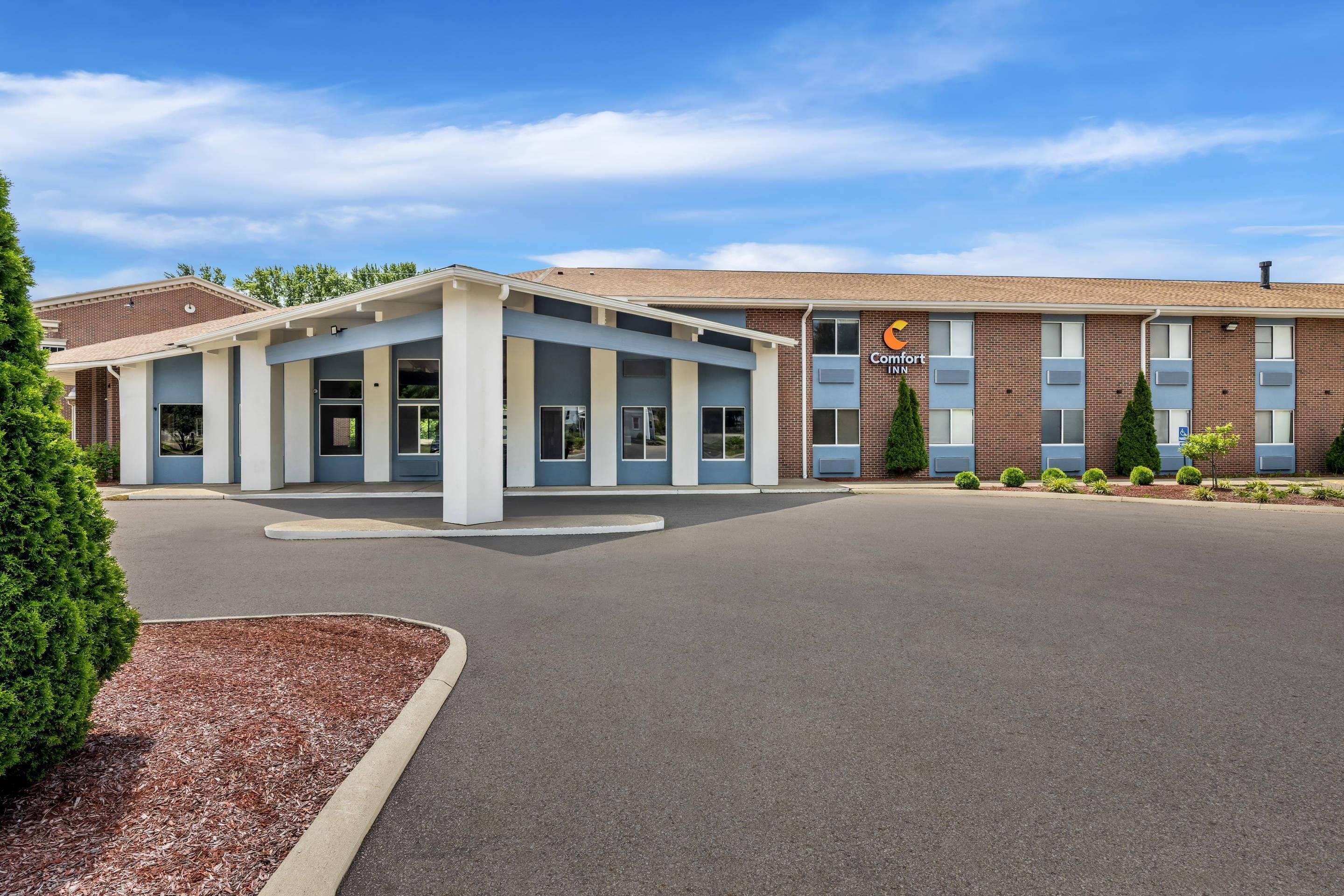 A Comfort Inn hotel with a central entrance, a brick building, and a parking lot.